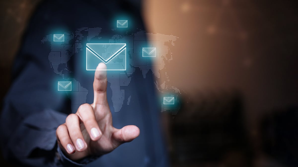Businessman interacting with digital email interface on virtual screen with global network background. Concept of email marketing, communication technology, data exchange and business connectivity.